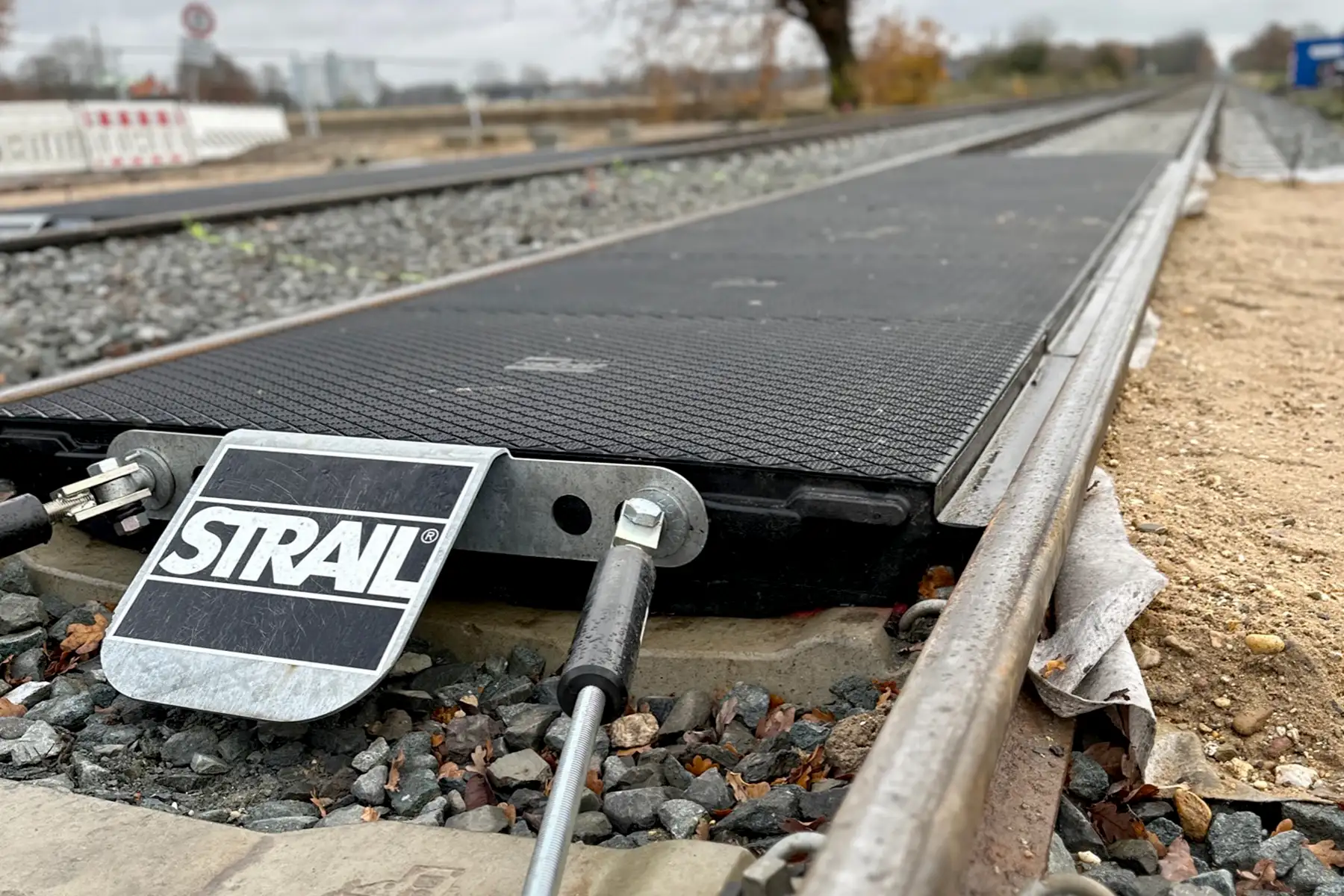 Detailaufnahme eines Bahnübergangs mit Logo-Aufdruck der Marke Strail